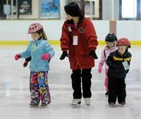 Image of children and a coach on the ice