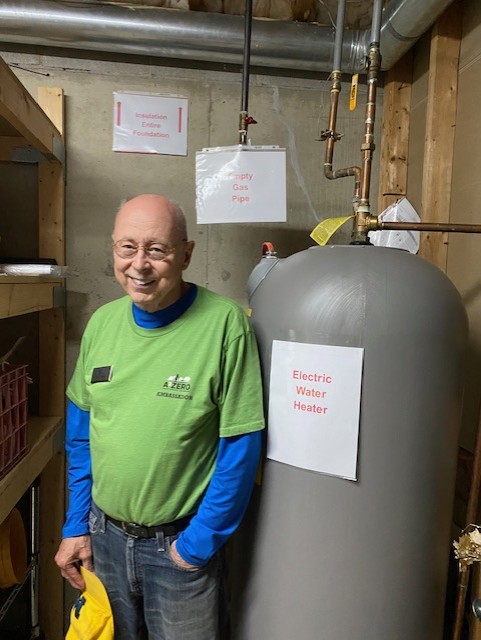 Person smiling next to electric water heater